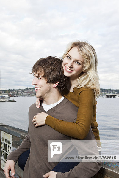 USA  Washington  Seattle  Young couple on pier  woman looking at camera
