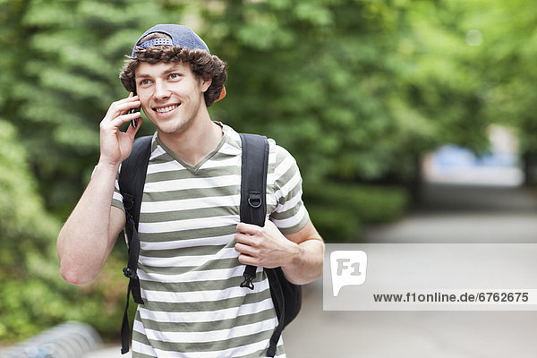 Male college student talking on cell phone