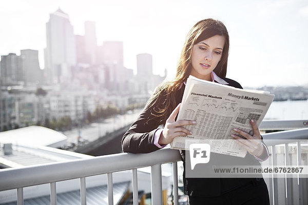 USA  Seattle  Young businesswoman reading newspaper
