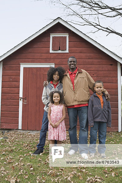 Family standing in front of barn