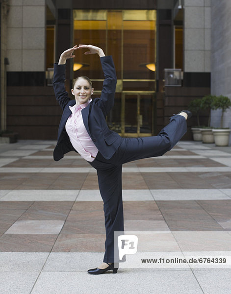 Businesswoman dancing in urban setting