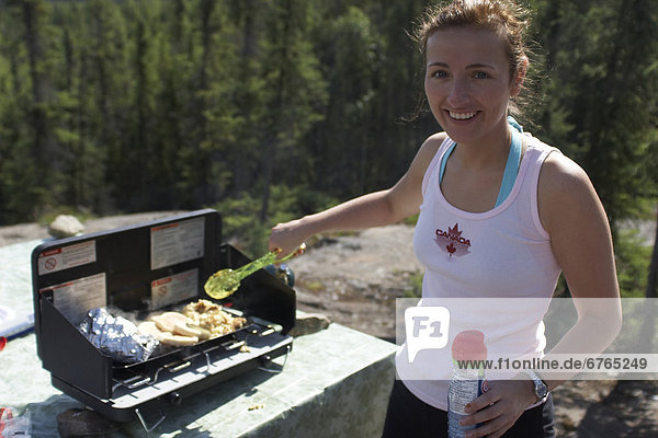 Camper cooking breakfast at the Reid Lake campground  found along the Ingraham Trail outside of Yellowknife  Northwest Territories