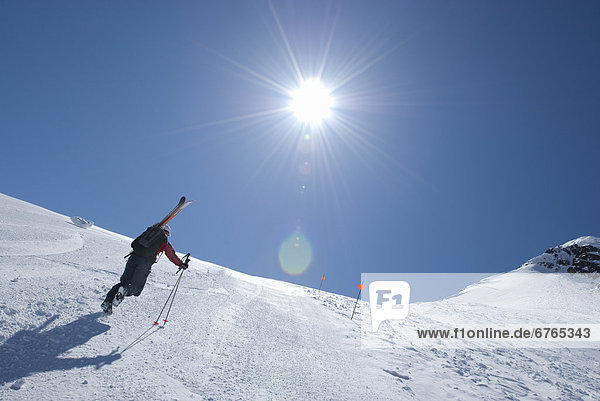 Skier walking up Blackcomb ski hill  heading for backcountry  Garibaldi Provincial Park  Whistler  British Columbia