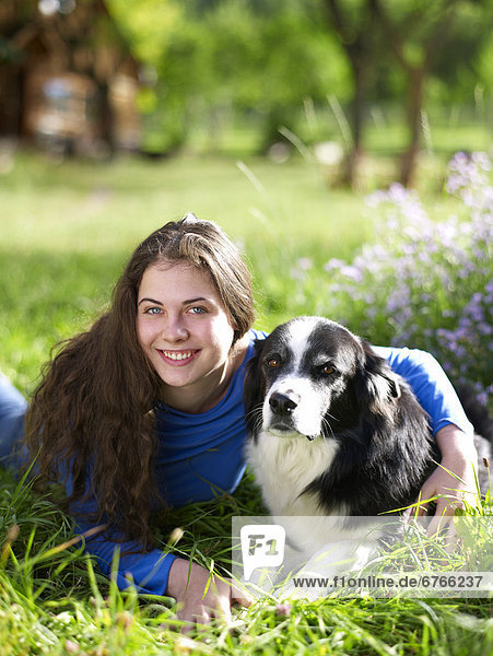 USA  Colorado  Portrait of young woman embracing dog on grass