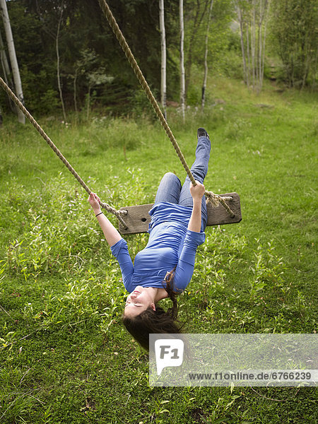 USA  Colorado  Young woman on swing in field