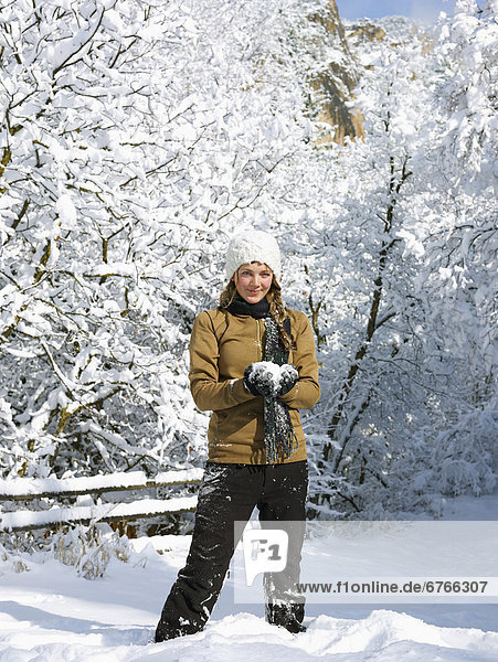 USA  Colorado  portrait of young woman making snowball