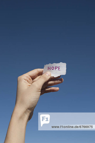 'USA  Arizona  Winslow  Human hand holding paper with ''hope'' text on it'