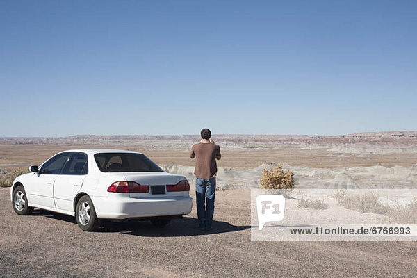 USA  Arizona  Painted Desert. Little Painted Desert  Man standing near car and looking at view