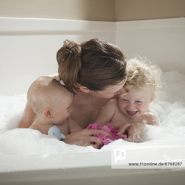 Mother and children having bubble bath