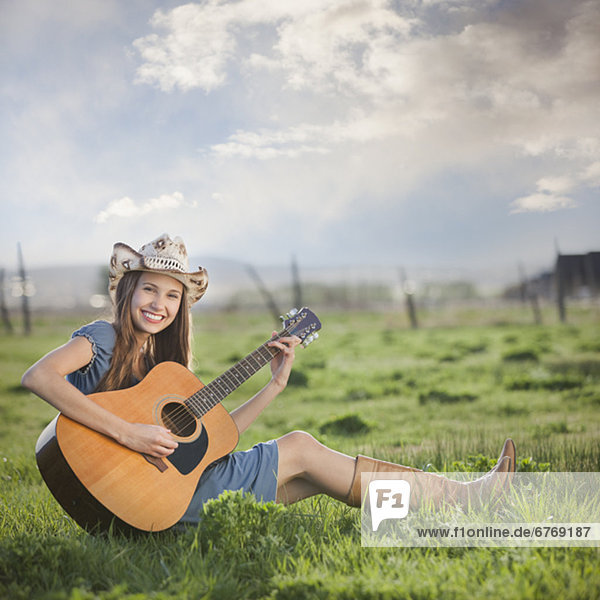sitzend  Feld  Gitarre  Cowgirl  spielen