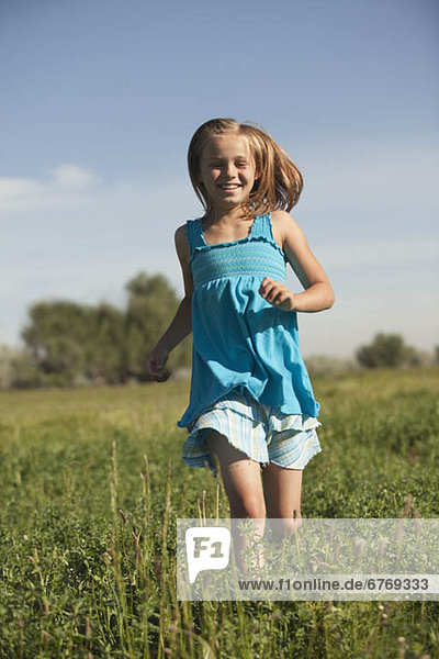 Young girl running in field