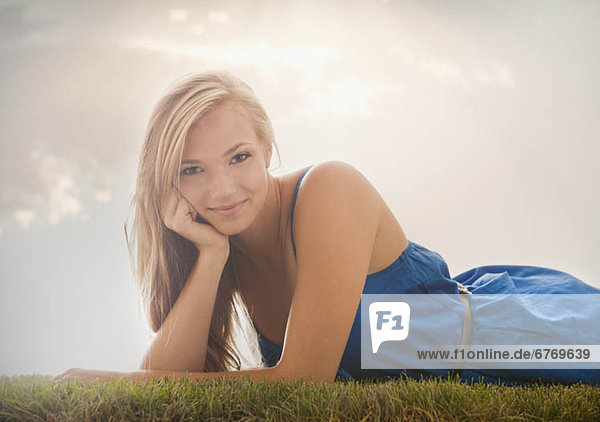 Young girl (16-17) lying on grass