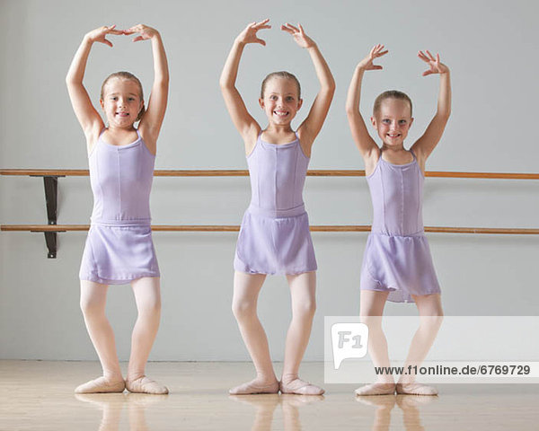 Portrait of three ballet dancers (6-7) in dance studio