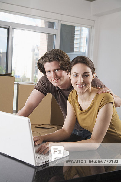 Man and Woman on Laptop in Empty Condo with Boxes  Toronto  Ontario