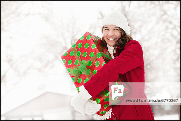 Vereinigte Staaten von Amerika USA Außenaufnahme junge Frau junge Frauen Portrait umarmen Weihnachtsgeschenk freie Natur