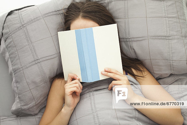 Junge Frau im Bett lesen
