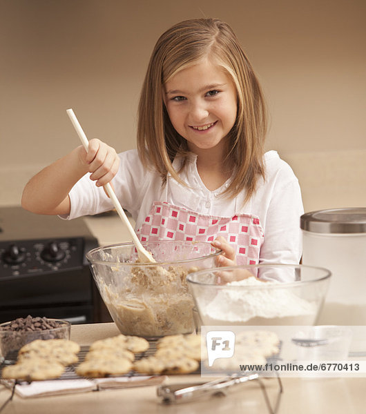 Portrait of girl (10-11) baking biscuits in kitchen