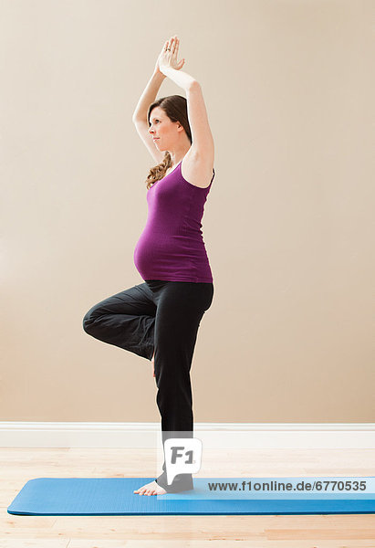 USA  Utah  Lehi  Young pregnant woman exercising  standing on one leg