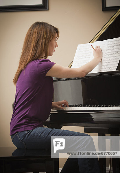 USA  Utah  Lehi  Young woman marking score before setting to play grand piano