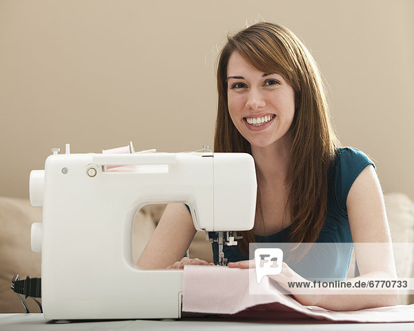 Vereinigte Staaten von Amerika USA junge Frau junge Frauen benutzen Portrait lächeln Maschine nähen