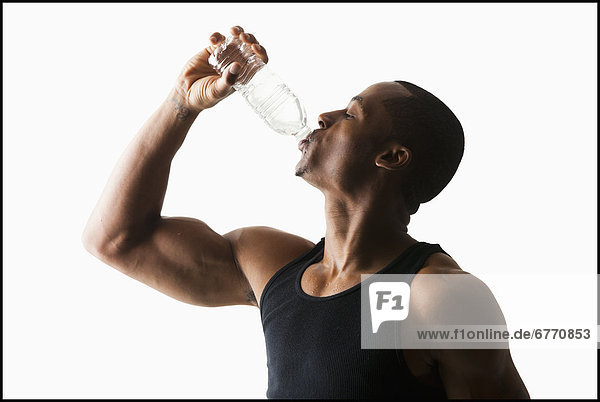 Studio shot of man drinking water from bottle