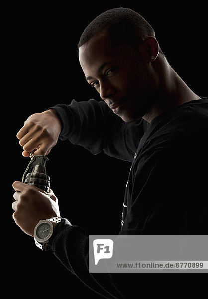 Studio portrait of young man holding grenade