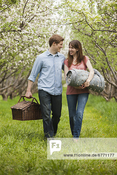 USA  Utah  Provo  Young couple with picnic basket in orchard