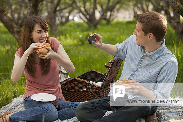 USA  Utah  Provo  Young couple having picnic in orchard