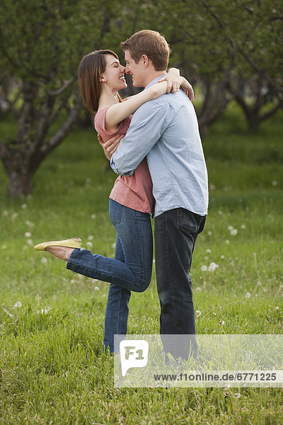 Young couple embracing in orchard