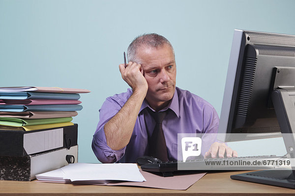 Overworked man sitting at his desk