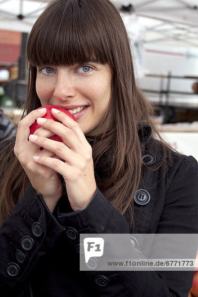 Woman at a local farmers market holding an apple  Toronto  Ontario