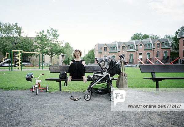 Woman on a bench in a park with a stroller  Montreal  Quebec