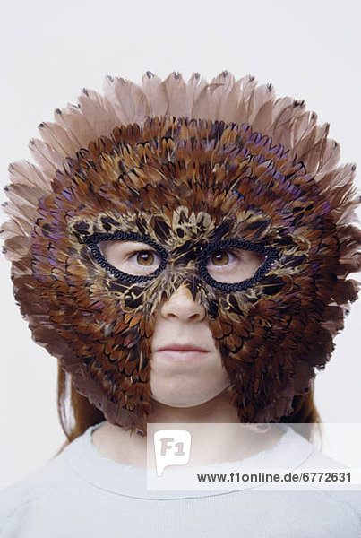 Child wearing a feather mask