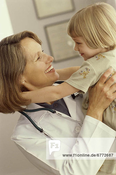 Doctor holding young girl