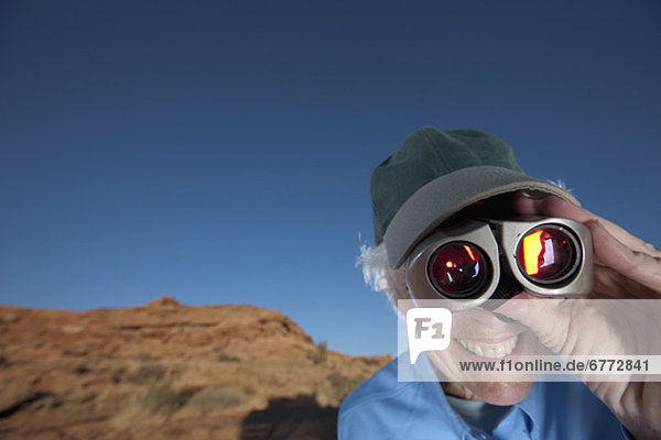 Elderly woman looking through binoculars