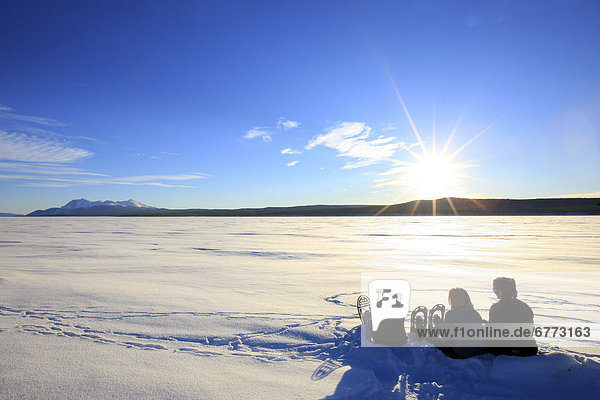Snowshoers taking a rest on the frozen Teslin Lake  Yukon