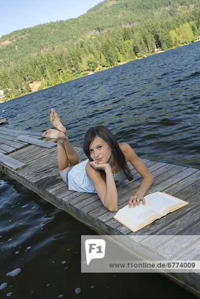 Teenager reading on a dock  Shawnigan Lake  Victoria  British Columbia