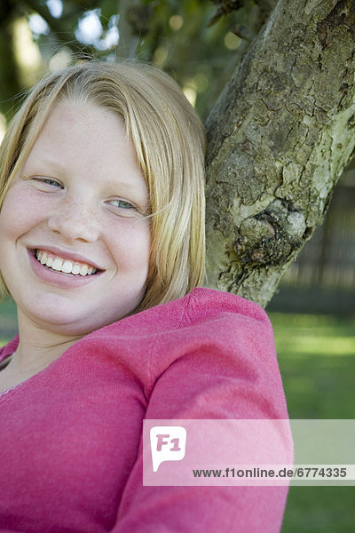 Teenage girl smiling in tree  Kelowna  British Columbia