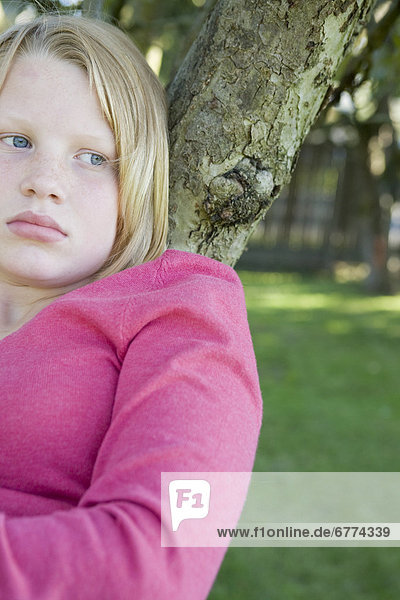 Unhappy teenage girl sitting in tree  Kelowna  British Columbia