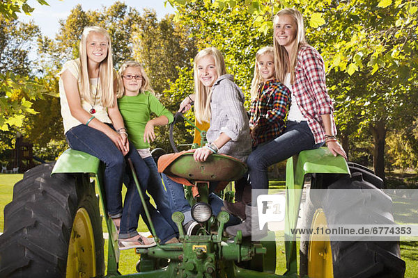 USA  Utah  family portrait of sisters (6-7  8-9  12-13  14-15  16-17) sitting on tractor