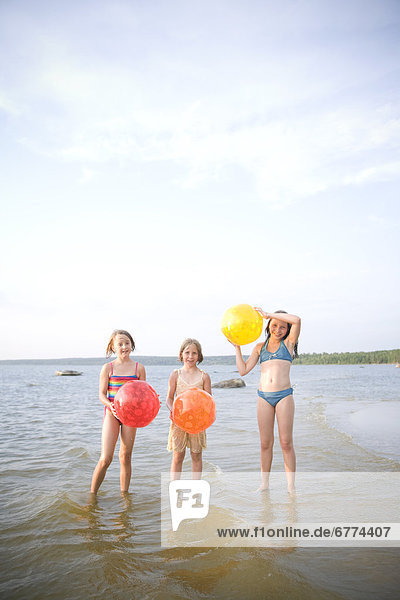 Three girls holding beach balls  Grand Beach  Manitoba