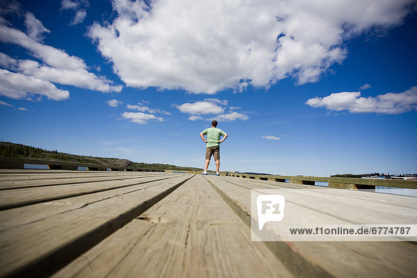 Man standing on a dock on the Back Bay portion of the Great Slave Lake  Yellowknife  Northwest Territories