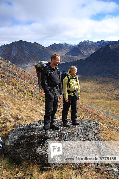 Couple hiking in autumn overlooking North Klondike Valley  Tombstone Territorial Park  Yukon