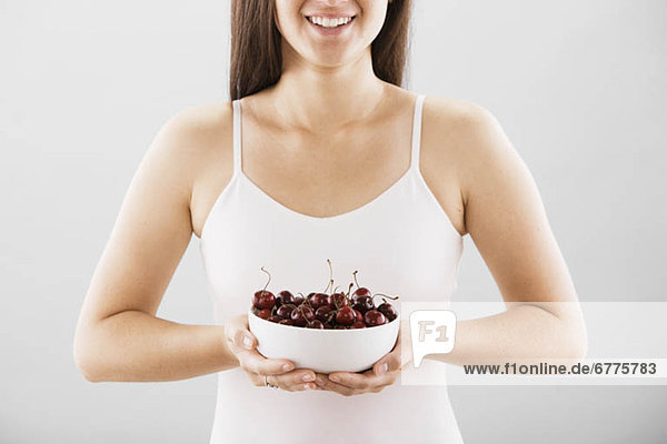 Woman holding a bowl of cherries