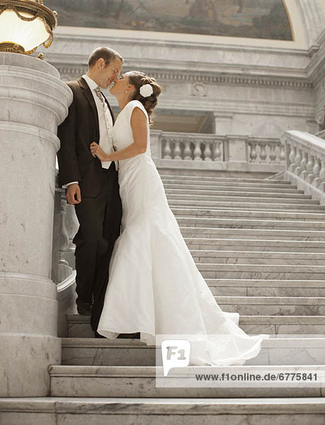 Bride and groom kissing on steps