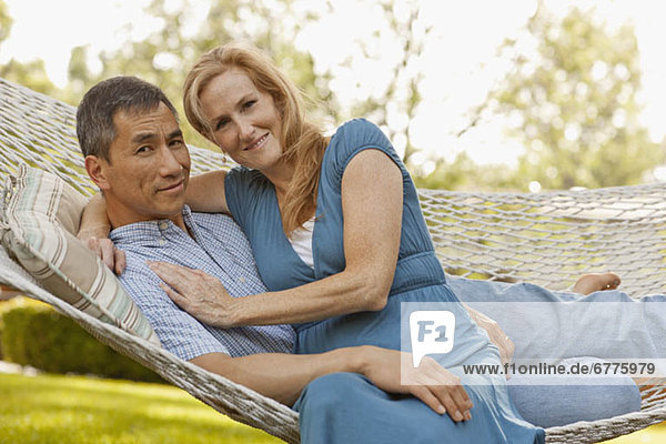 USA  Utah  Provo  Portrait of smiling mature couple relaxing in hammock in garden