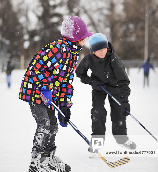 Boys playing ice hockey on an outdoor rink  Winnipeg  Manitoba  Canada
