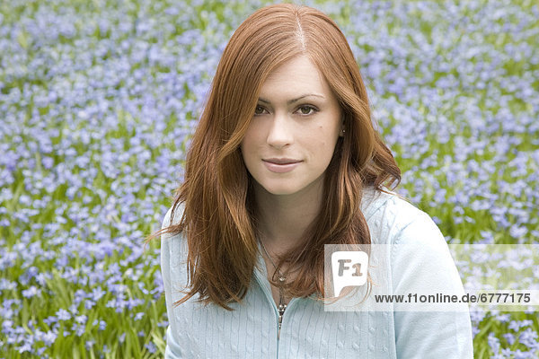 Red-haired young woman in a field of blue flowers  Whitby  Ontario  Canada