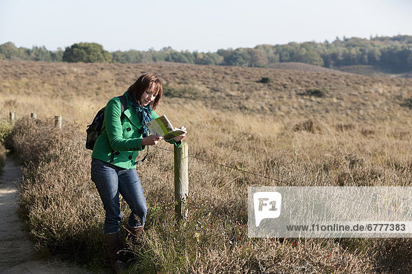 The Netherlands  Veluwezoom  Posbank  Woman reading guidebook in countryside