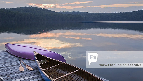 Canoes and paddles on dock at sunset  Smoke Lake  Algonquin Park  Ontario